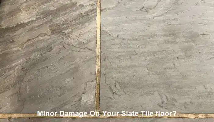 Localized slate floor damage beside stable surrounding tiles requiring repair assessment
